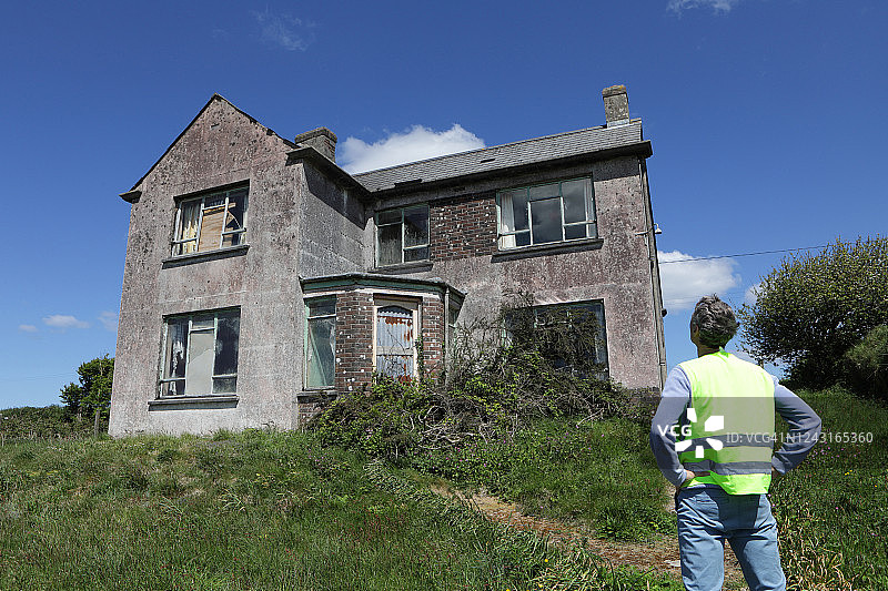 男人观看破旧的废弃房屋图片素材
