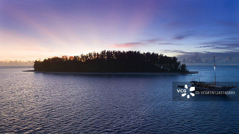 停泊在无人热带岛屿附近的船只图片素材