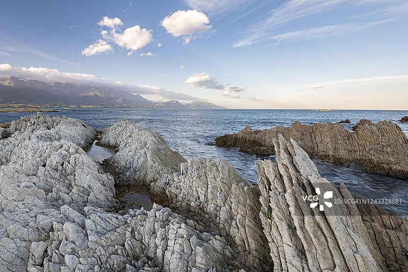 凯库拉半岛岩石海岸，背景是凯库拉山脉，新西兰南岛坎特伯雷图片素材