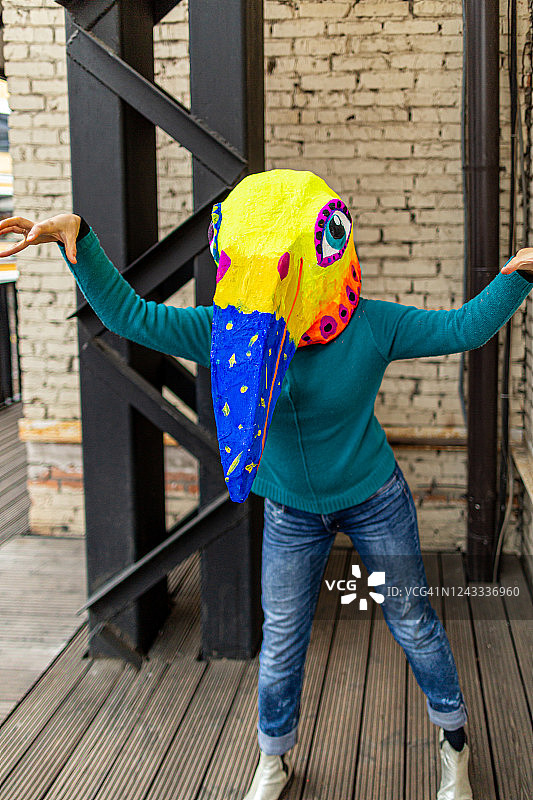 戴着手工鸟头面具的女人图片素材