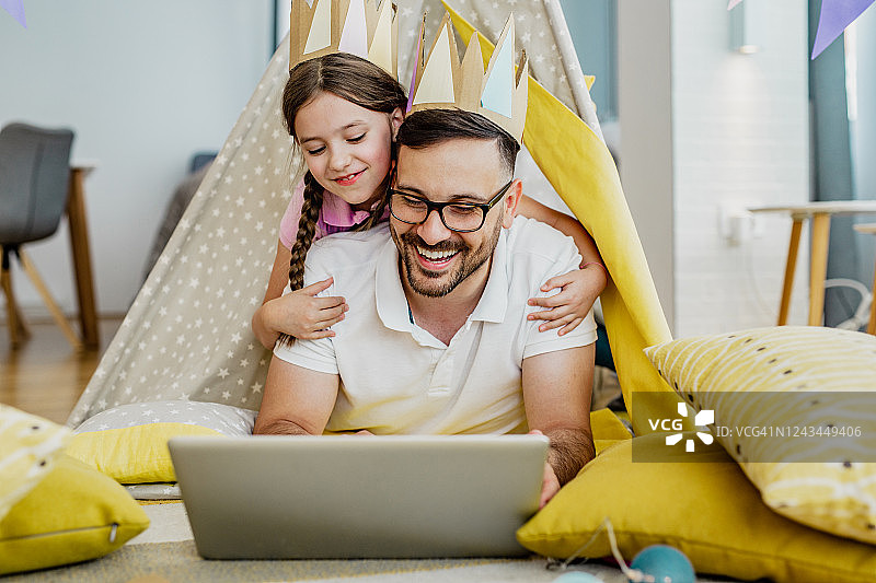父女在家中使用笔记本电脑图片素材