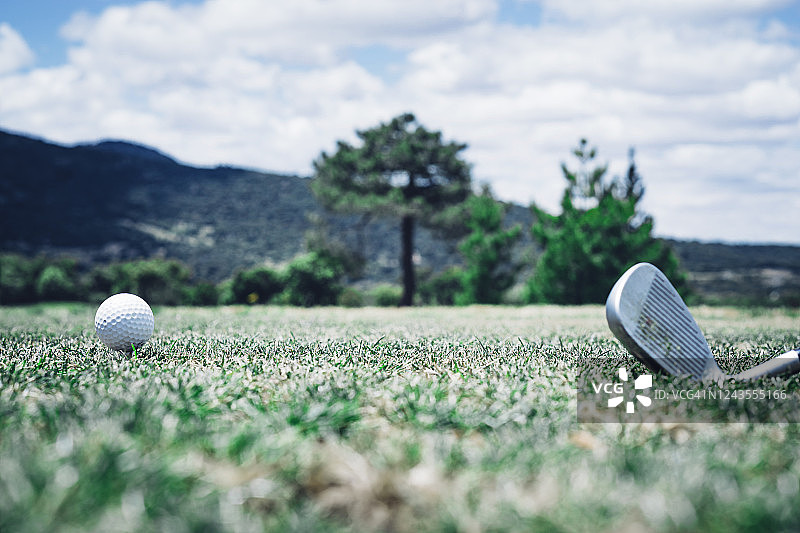 在豪华球场练习高尔夫运动的素材：球杆和白色高尔夫球图片素材