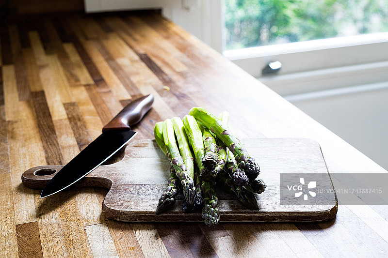 带厨房刀的木制砧板上的芦笋图片素材