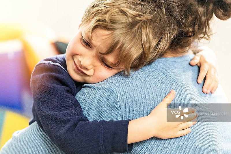 悲伤的小男孩拥抱妈妈图片素材
