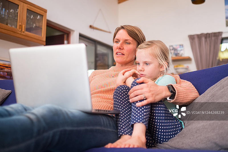母女在沙发上看故事图片素材