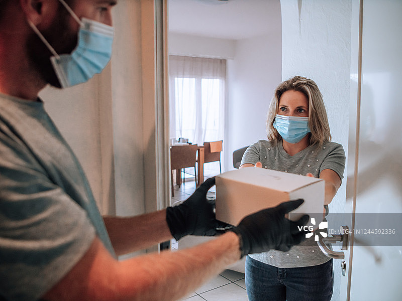 快递员在冠状病毒期间将包裹送到顾客家中图片素材