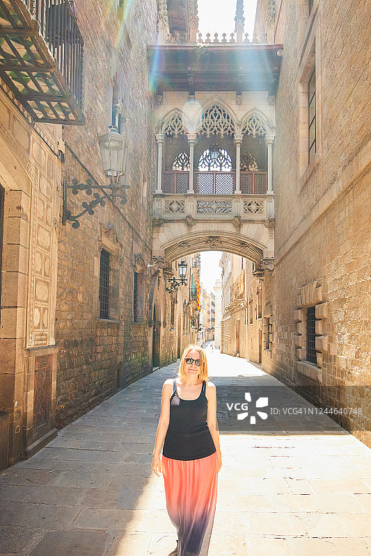 在西班牙巴塞罗那哥特区，一位女士走过主教桥图片素材