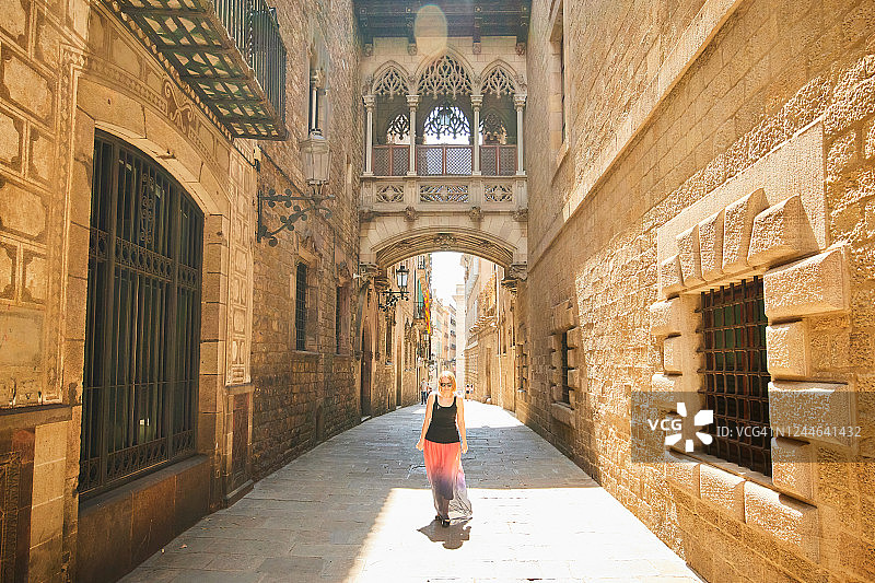 在西班牙巴塞罗那哥特区，一位女士走过主教桥图片素材
