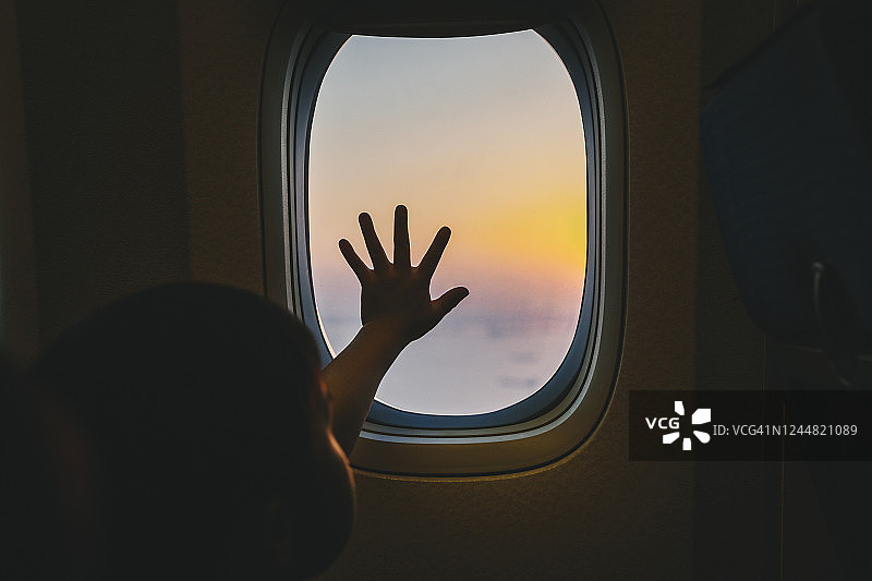 男孩从飞机窗口看风景图片素材