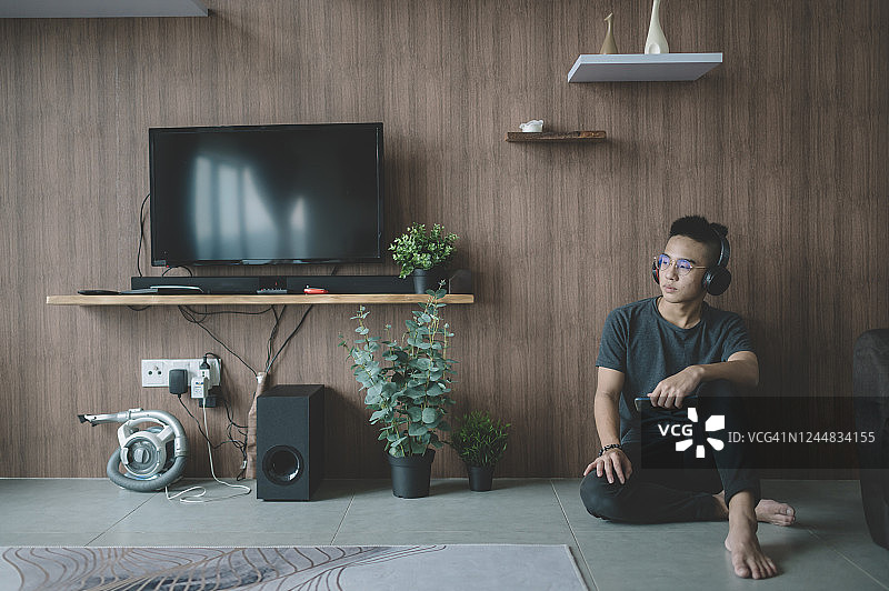 中国青少年男孩戴着耳机听音乐图片素材