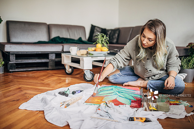 女画家在家中地板上绘画图片素材