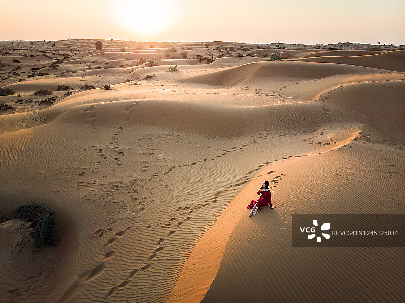 沙漠沙丘上的红裙女人图片素材