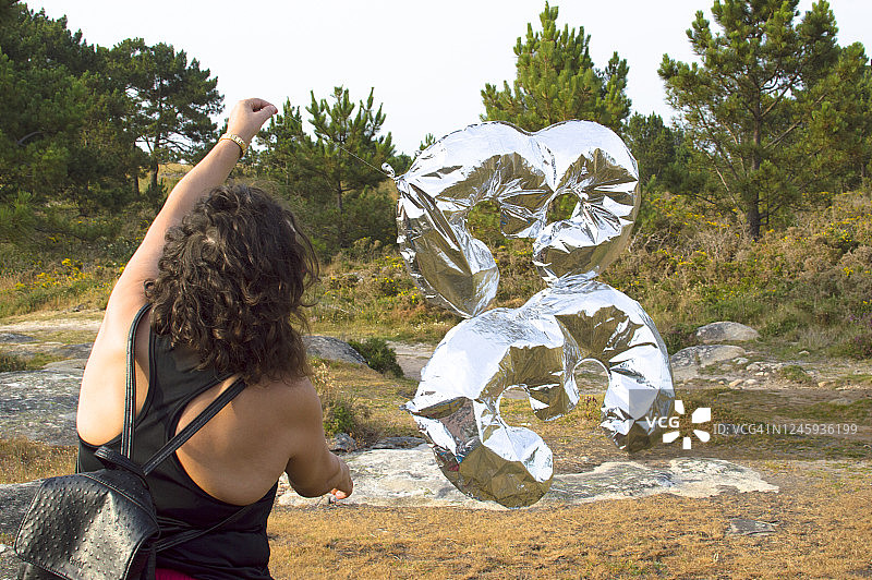 在森林中拿着33号气球行走的女人图片素材