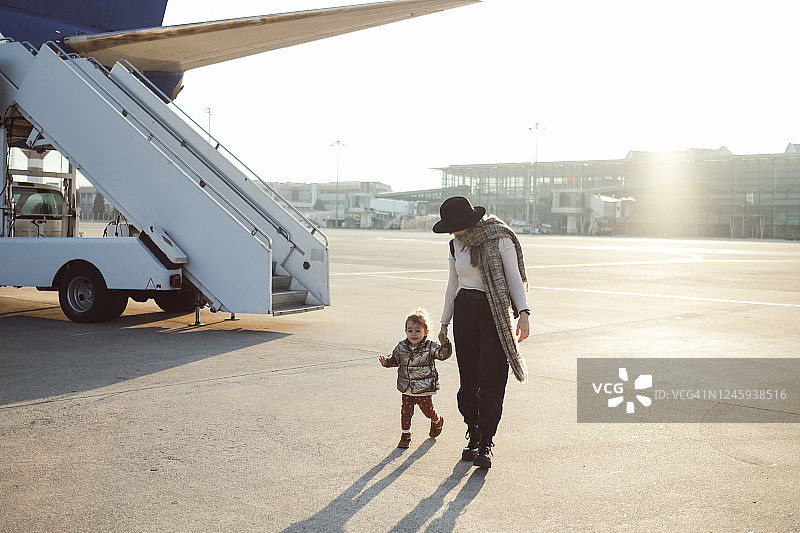 快乐的单身母亲和儿子登机图片素材