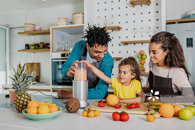 年轻家庭在厨房准备健康饮品图片素材