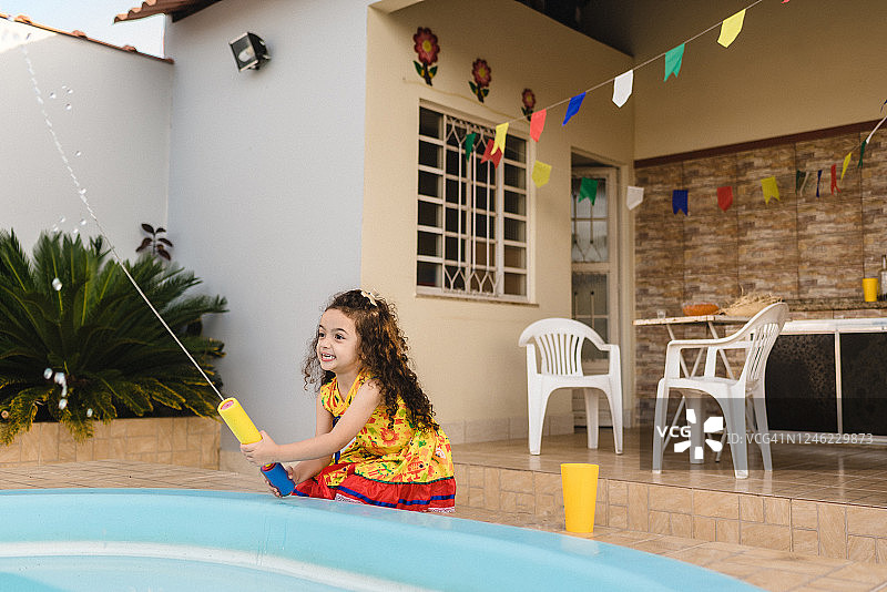 在院子里玩水枪的女孩图片素材