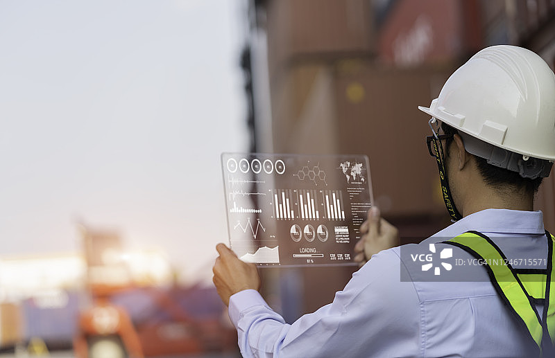 监督员用平板电脑检查集装箱货场中的货物运输图片素材