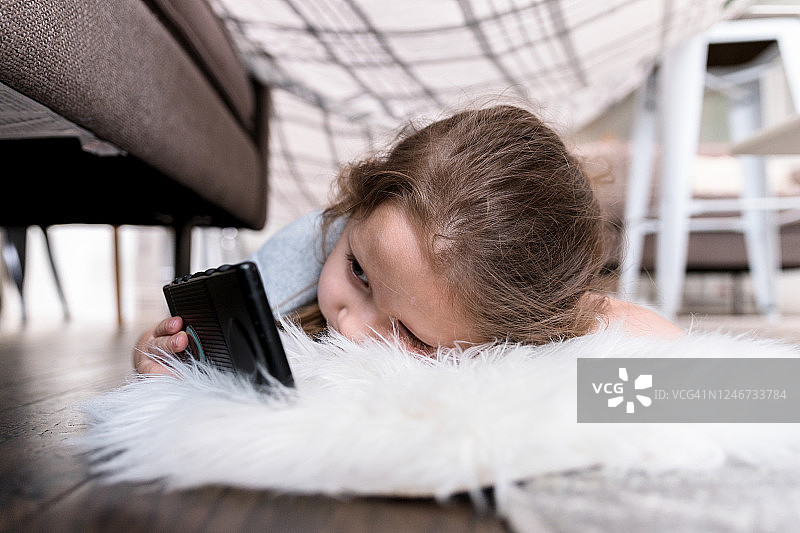 女孩在自制堡垒里玩手机游戏图片素材