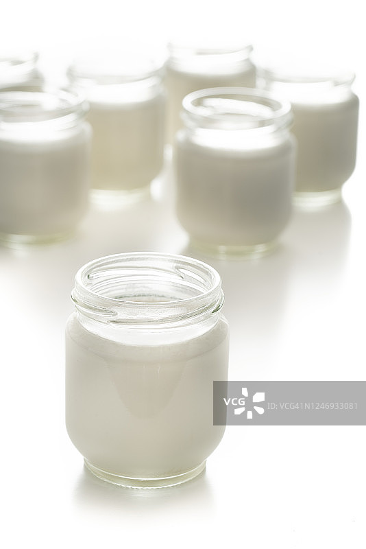 白色背景下的玻璃罐装自制酸奶图片素材
