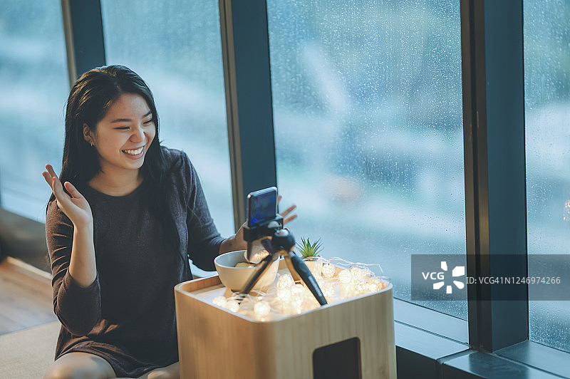 雨天亚裔中国少女房间里拍Vlog吃苹果微笑图片素材