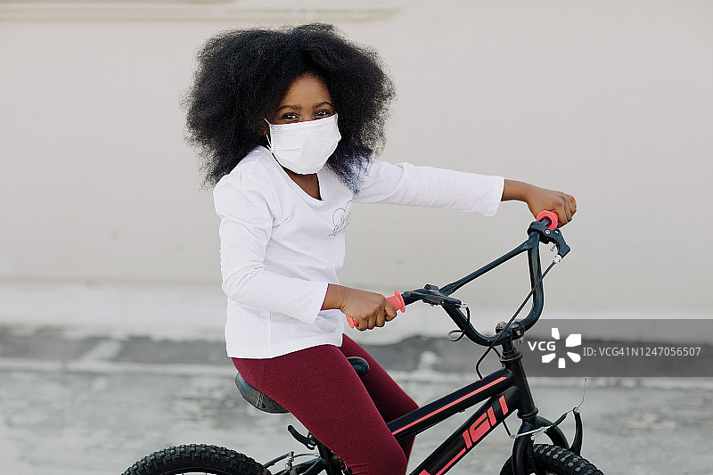 年轻女孩戴着口罩骑自行车图片素材