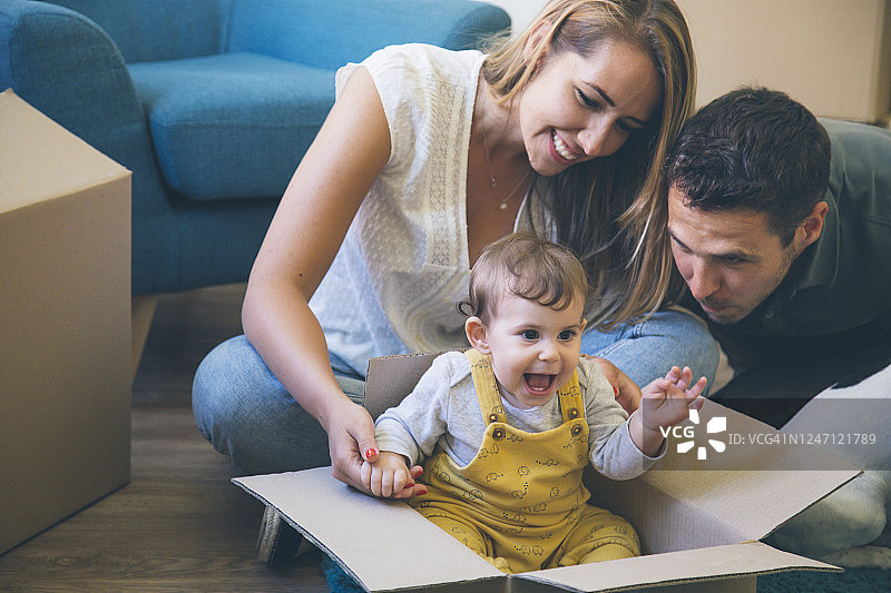 快乐的父母在新家和女儿玩耍图片素材