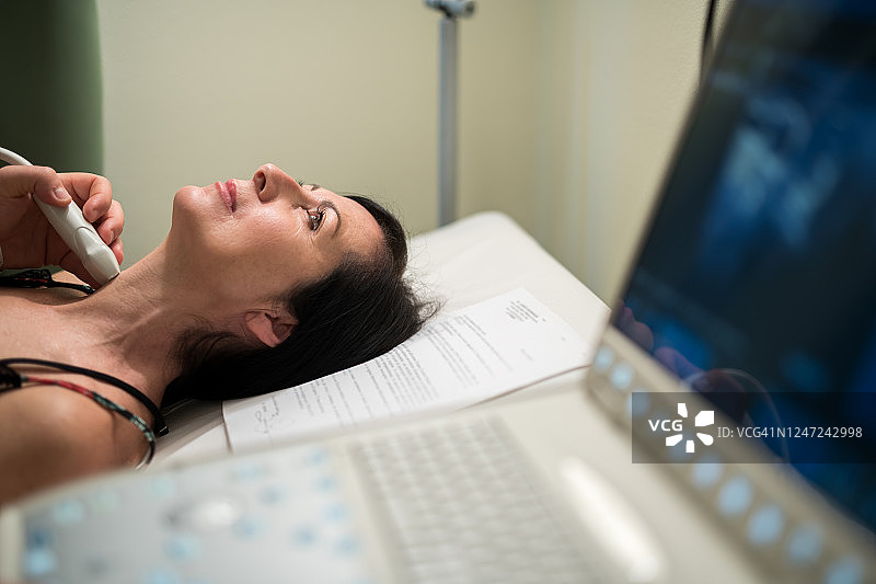 癌症预防：内分泌医生为成年女性检查甲状腺超声图片素材