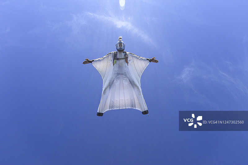 翼装飞行员翱翔于山脉和云层之上图片素材