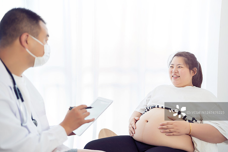 医生用数字平板电脑与孕妇交流图片素材