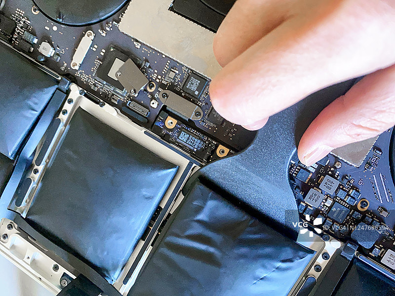 拆解鼓包的笔记本电脑更换电池图片素材