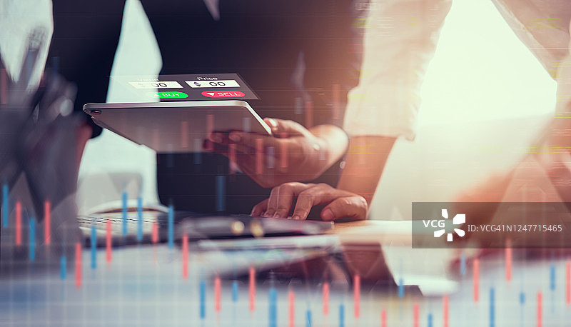 股票交易市场概念，交易员团队在办公室用平板电脑分析图表和蜡烛线图片素材