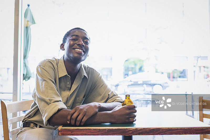 年轻男子坐在咖啡馆的桌旁图片素材