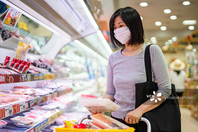 中年妇女戴着防护口罩购买食品图片素材