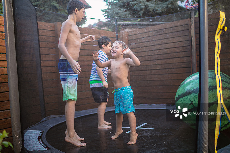 兄弟在蹦床上玩耍图片素材