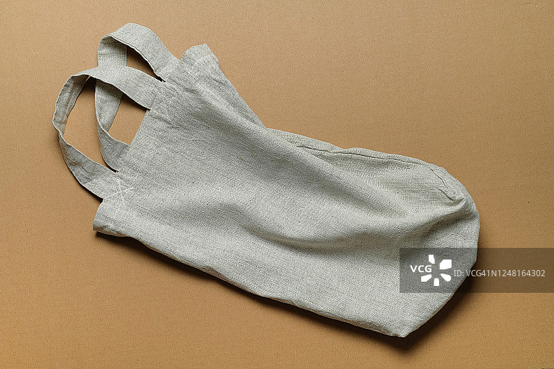 可重复使用的购物袋，用回收原材料制成的绳子袋，隔离在米色背景上图片素材