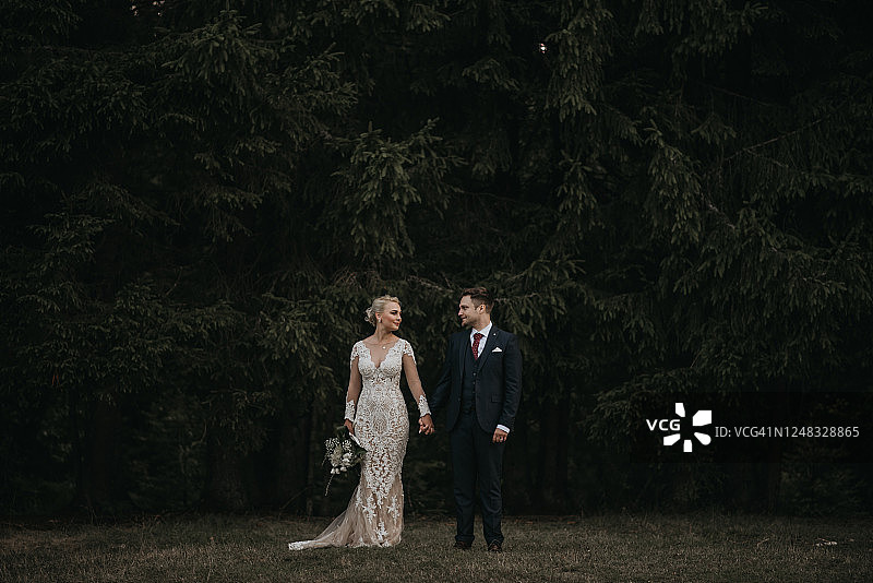 美丽的新娘和新郎在森林里享受浪漫时光，风吹麦浪图片素材