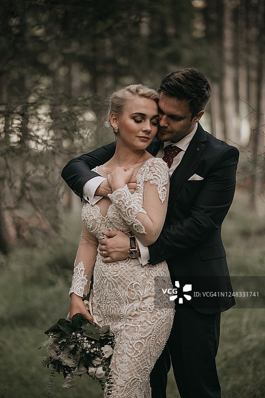 美丽的新娘和新郎在森林里享受浪漫时光，风吹麦浪图片素材