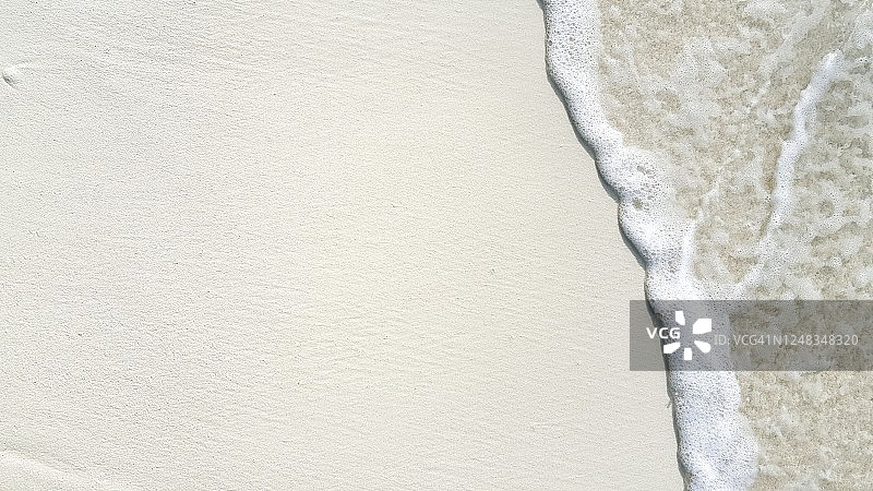 海浪拍打沙滩的特写，海滩度假图片素材