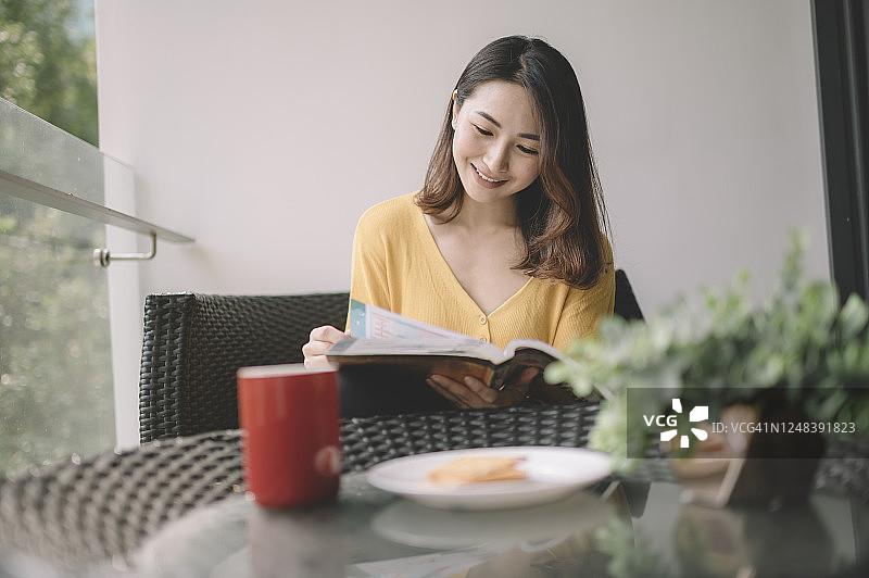 在阳台上放松身心、享受数字排毒时光的亚洲美丽女性图片素材