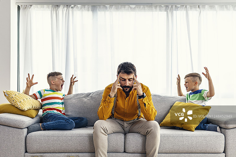 厌倦吵闹孩子的沮丧单身父亲图片素材