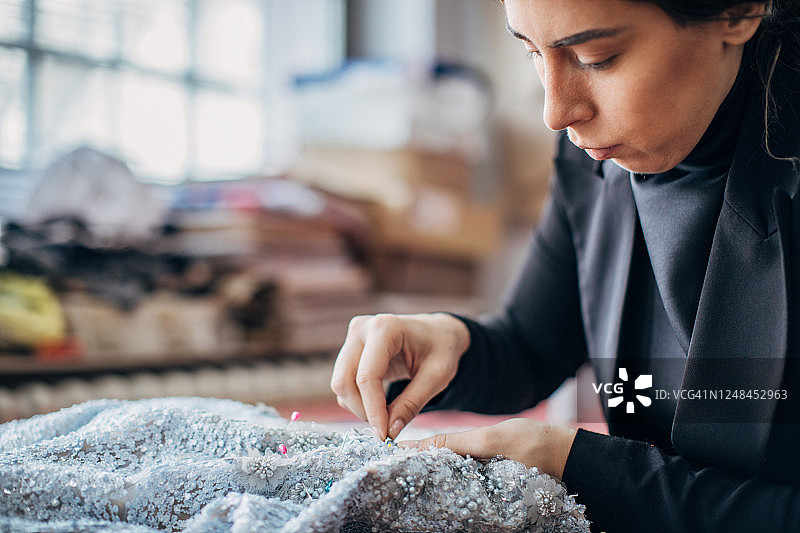 时装设计师在工作室用针缝纫图片素材