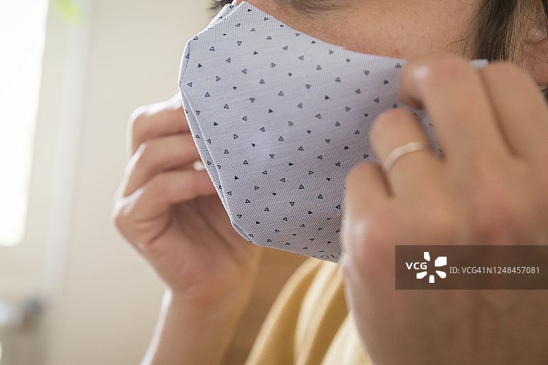 女人试戴自制医用口罩，法国蒙塔基图片素材