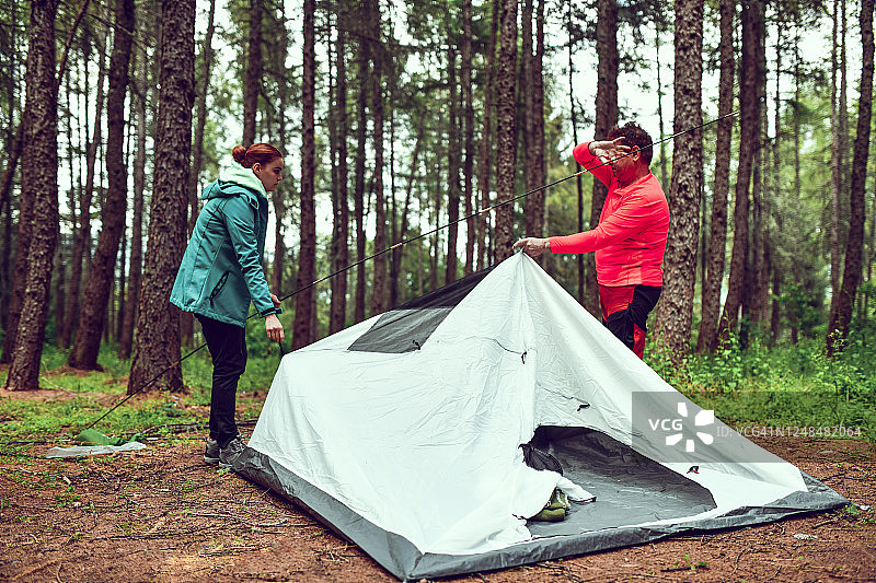 老年男子帮助女性搭建帐篷图片素材