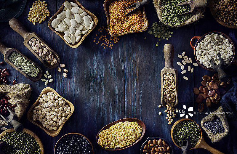 各种干豆在蓝色木桌上构成框架的俯视低调照片图片素材