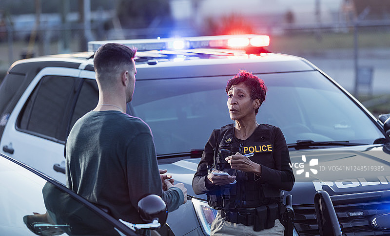 女警员向一名年轻男子录取口供图片素材