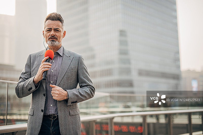 一位正在直播中播报新闻的男记者图片素材