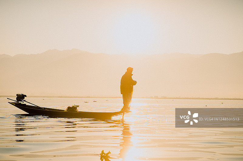 缅甸掸邦茵莱湖日出时分的茵达渔民，茵达渔民的传统腿划船方式图片素材