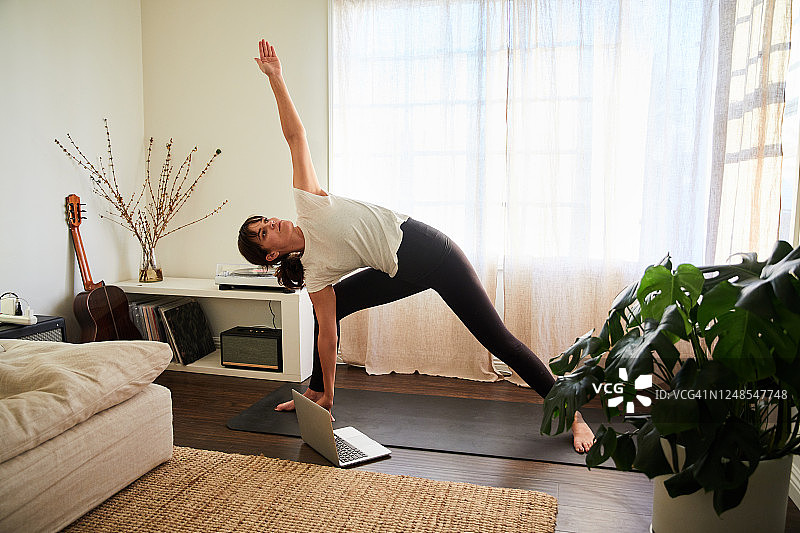 女人在线瑜伽课上练习侧板式图片素材