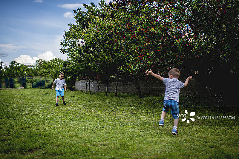 在后院踢足球的男孩们图片素材