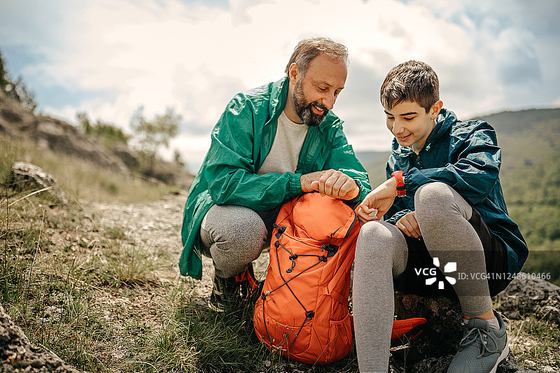 父子在户外休息时看时间图片素材